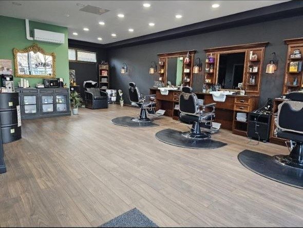 La salle du salon : fauteuils de barbier, coiffeuses en bois et miroirs encadrés